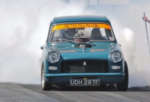 Picture of a Herald drag race car owned by Tony North performing a burn out.